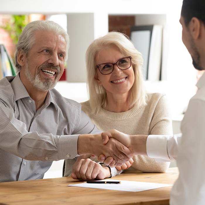 elder couple shaking hands with insurance agent after meeting chesapeake va